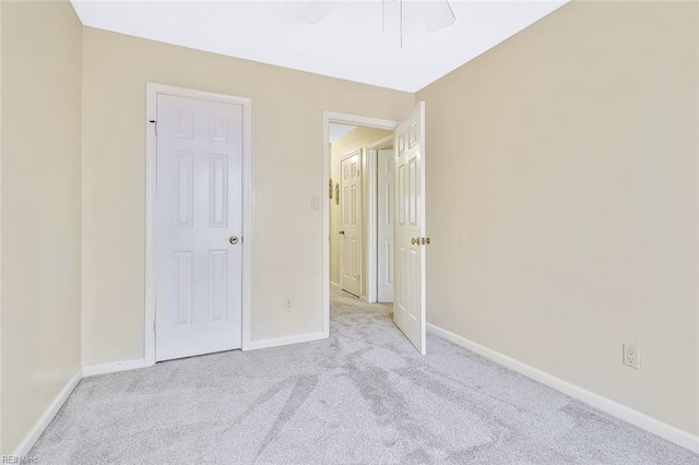 unfurnished bedroom featuring light colored carpet and ceiling fan