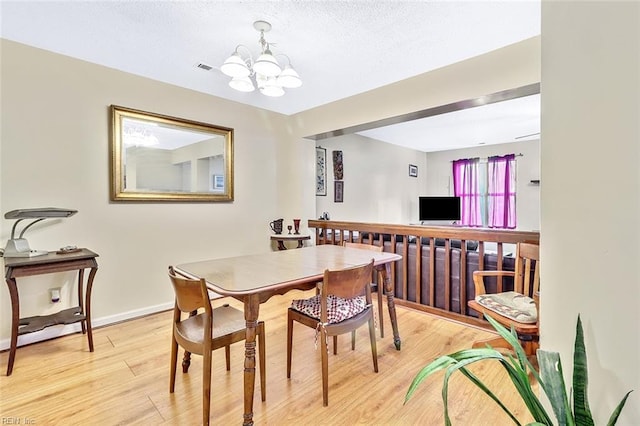 dining room with an inviting chandelier and light hardwood / wood-style flooring