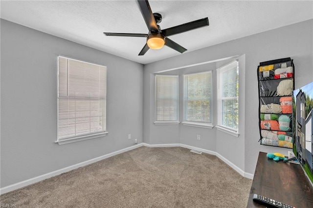 carpeted spare room featuring ceiling fan