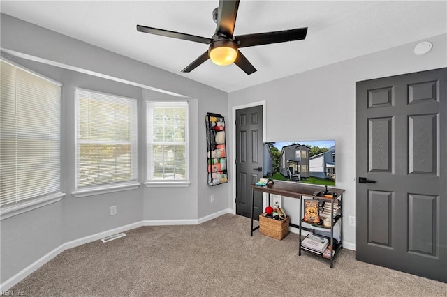 misc room featuring light colored carpet and ceiling fan