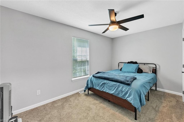 bedroom featuring heating unit, light carpet, and ceiling fan