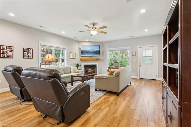 living room featuring ceiling fan, a healthy amount of sunlight, and light hardwood / wood-style flooring