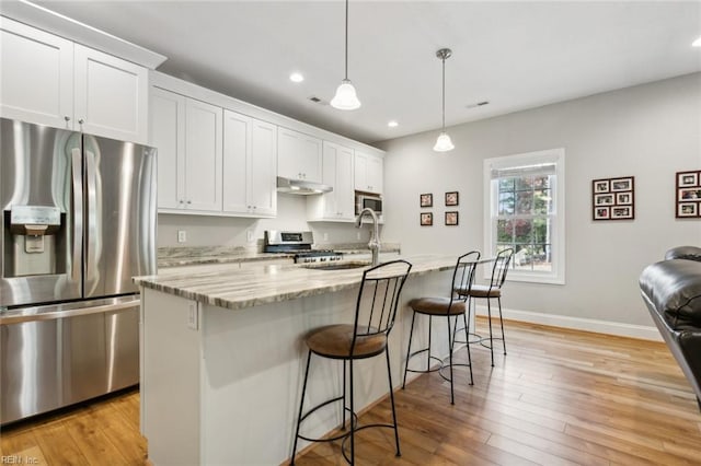 kitchen featuring white cabinets, light hardwood / wood-style flooring, sink, an island with sink, and appliances with stainless steel finishes