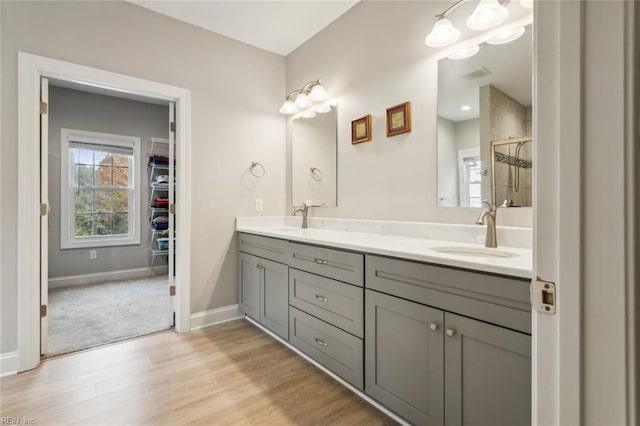 bathroom featuring walk in shower, wood-type flooring, and vanity