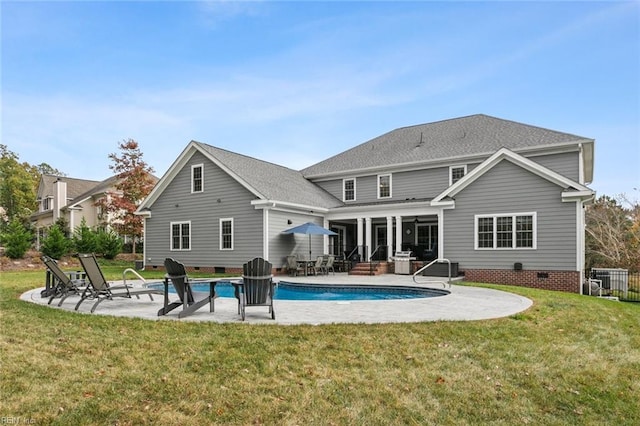 back of property with a lawn and a patio