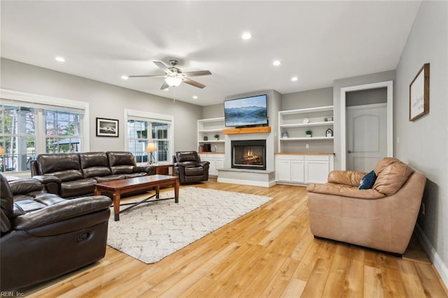 living room with ceiling fan and light hardwood / wood-style flooring