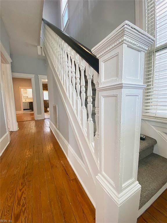 stairway with a wealth of natural light and wood-type flooring