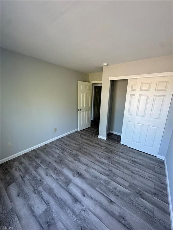 unfurnished bedroom featuring a closet and dark hardwood / wood-style floors