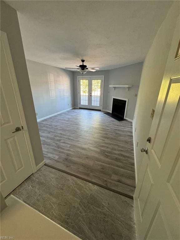 unfurnished living room with hardwood / wood-style flooring, ceiling fan, and french doors