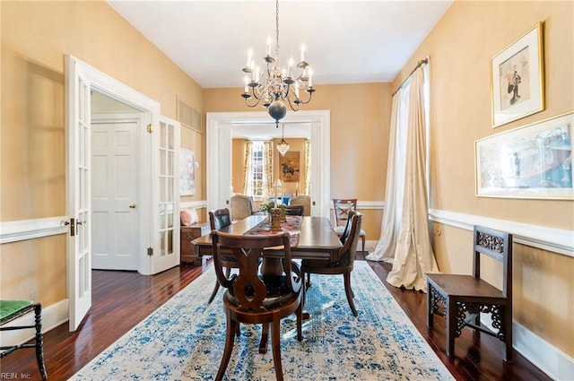 dining space with french doors, dark hardwood / wood-style flooring, and a chandelier