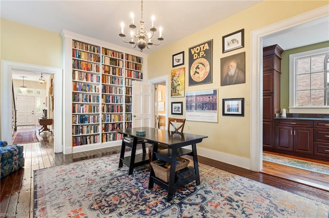 office area with wood-type flooring and an inviting chandelier