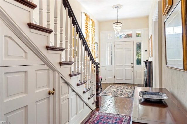 entrance foyer featuring dark wood-type flooring and a notable chandelier