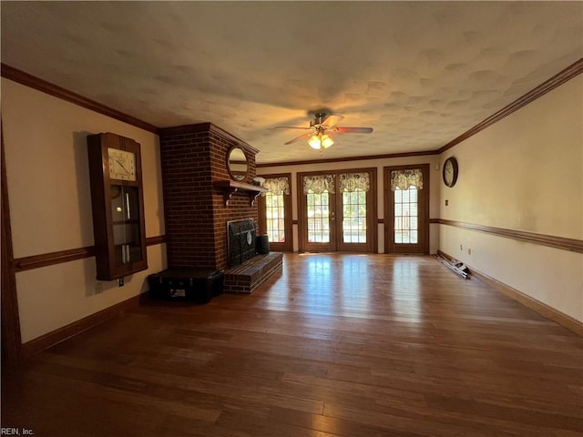 unfurnished living room with ornamental molding, a fireplace, dark hardwood / wood-style flooring, and ceiling fan