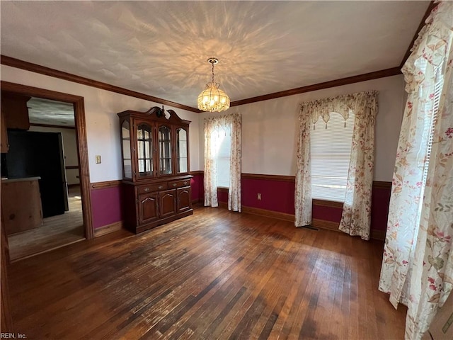 unfurnished dining area featuring ornamental molding, a wealth of natural light, and dark hardwood / wood-style flooring