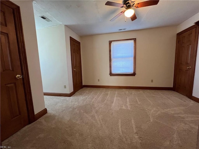 unfurnished bedroom with ceiling fan and light colored carpet