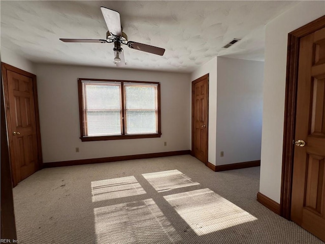 unfurnished bedroom with light colored carpet and ceiling fan