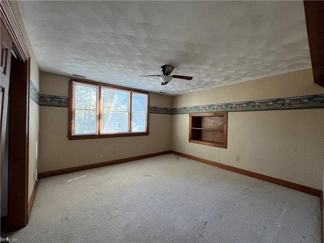 unfurnished room featuring ceiling fan, a textured ceiling, and carpet flooring