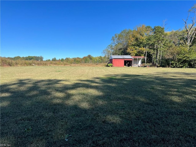 view of yard with an outbuilding and a rural view