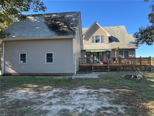 rear view of house featuring a wooden deck and a yard