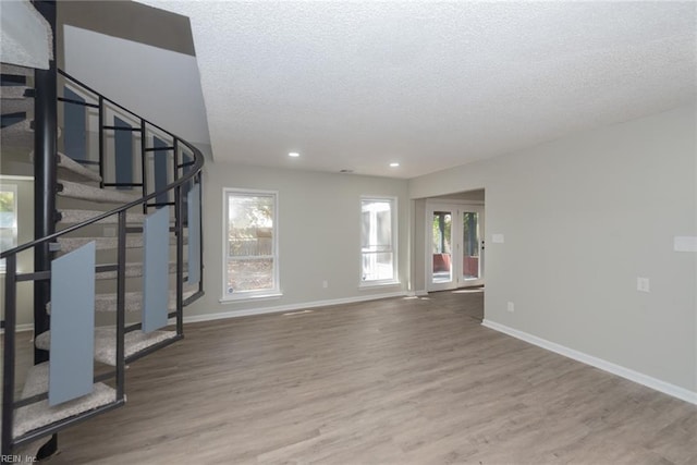 interior space featuring a wealth of natural light, wood-type flooring, and a textured ceiling