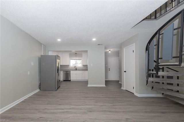 living room with hardwood / wood-style flooring, a textured ceiling, and sink