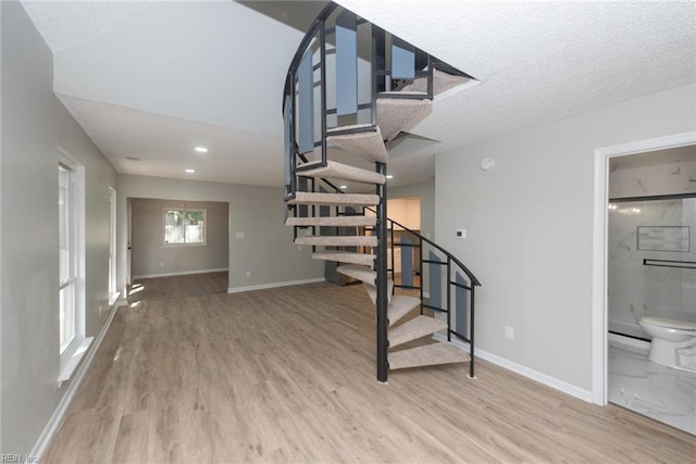 stairs featuring hardwood / wood-style floors and a textured ceiling