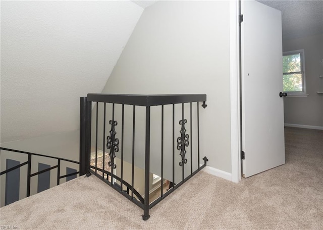 stairs featuring a textured ceiling and carpet flooring