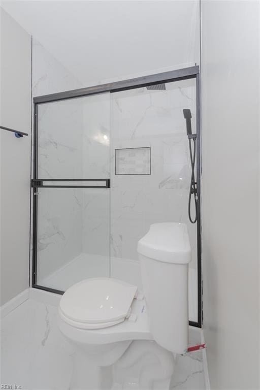 bathroom with toilet and a shower with shower door