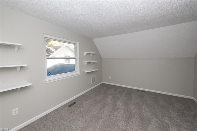 bonus room with dark colored carpet, a textured ceiling, and vaulted ceiling