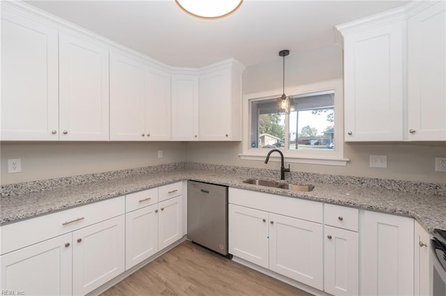 kitchen with stainless steel appliances, light stone counters, white cabinets, sink, and light wood-type flooring