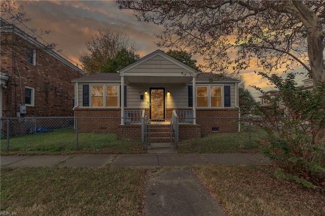 bungalow featuring a porch and a lawn