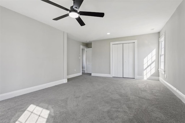 unfurnished bedroom featuring carpet, ceiling fan, and a closet