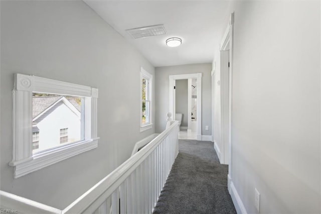 hall featuring dark colored carpet