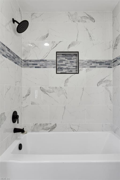 bathroom featuring tiled shower / bath