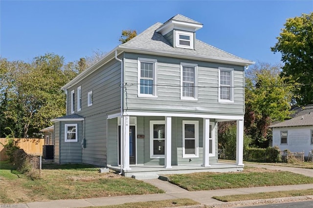 view of front of property featuring central air condition unit, a front yard, and covered porch