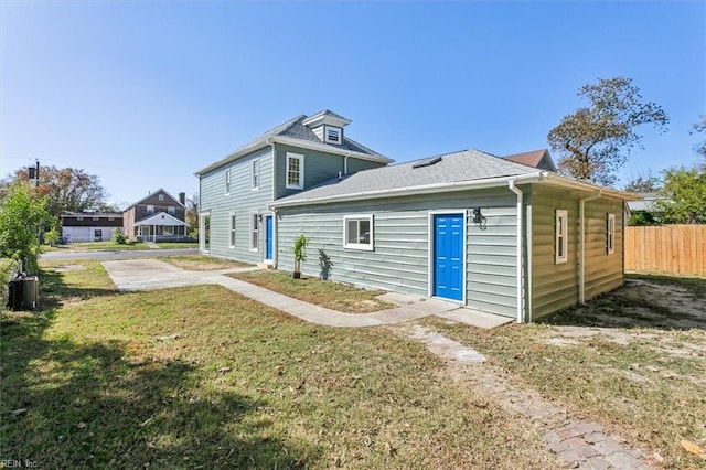 rear view of property featuring a yard