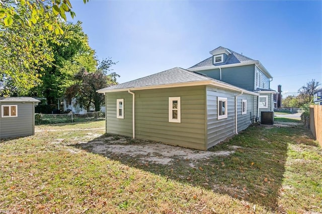 view of property exterior with a lawn and cooling unit