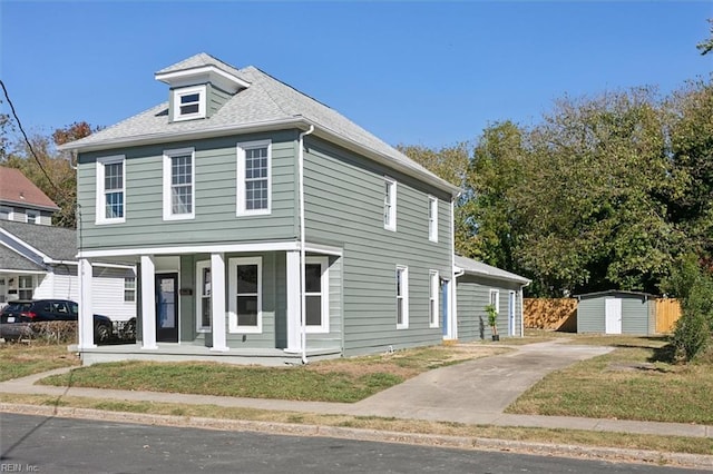 view of front of property featuring covered porch and a storage shed