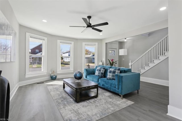 living room featuring dark wood-type flooring and ceiling fan