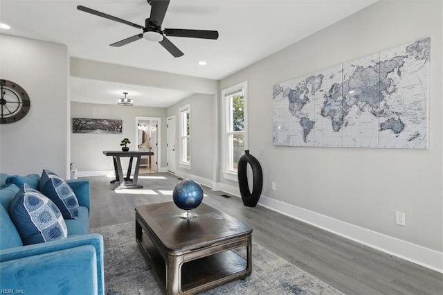 living room featuring dark wood-type flooring and ceiling fan