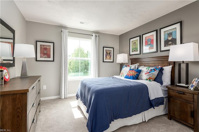 bedroom featuring a textured ceiling and light colored carpet