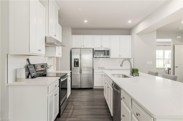 kitchen with white cabinetry, sink, dark wood-type flooring, a center island with sink, and appliances with stainless steel finishes