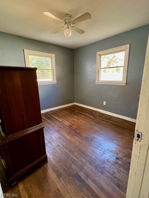 spare room featuring ceiling fan and dark wood-type flooring