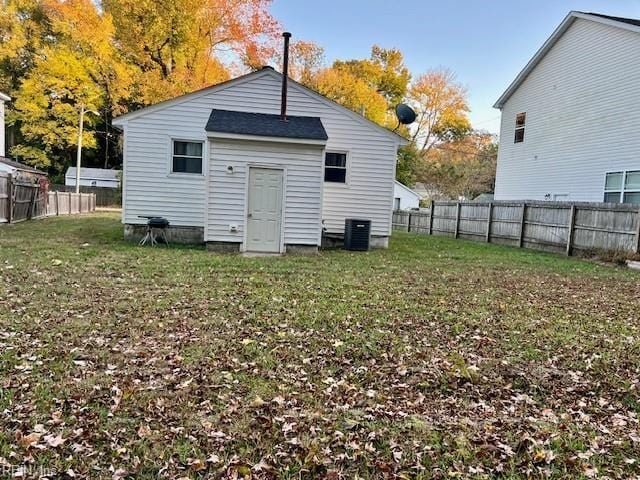 rear view of property with a yard and central AC unit