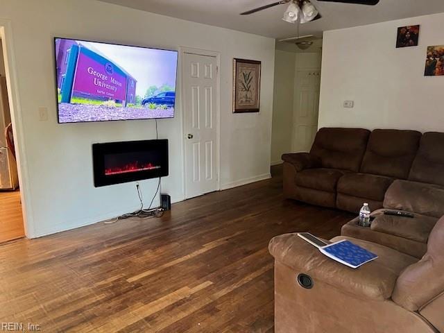 living room featuring ceiling fan and dark hardwood / wood-style flooring