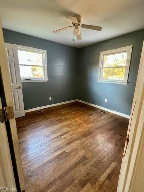 spare room featuring ceiling fan, plenty of natural light, and dark hardwood / wood-style floors