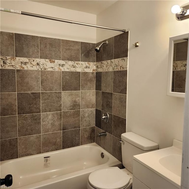 full bathroom featuring tiled shower / bath combo, toilet, and vanity