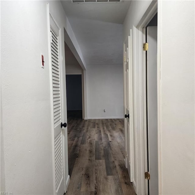 corridor with dark hardwood / wood-style flooring