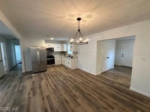 kitchen with pendant lighting, dark hardwood / wood-style flooring, white cabinetry, and stainless steel appliances