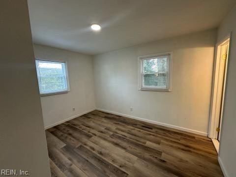 unfurnished room with dark wood-type flooring